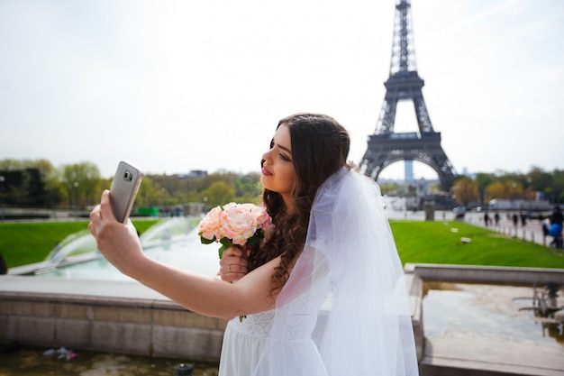 Noiva linda no vestido de casamento rico gira na praça