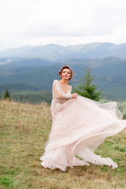 Noiva linda posando em seu vestido de noiva em um fundo de montanhas.