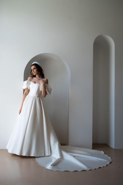 Noiva linda posando no vestido de casamento em uma foto branca Studio