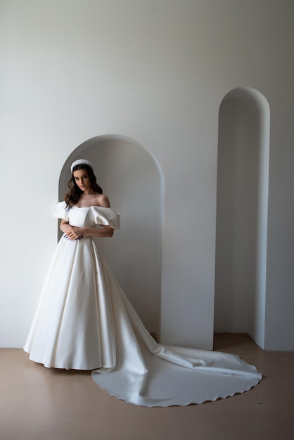 Noiva linda posando no vestido de casamento em uma foto branca Studio