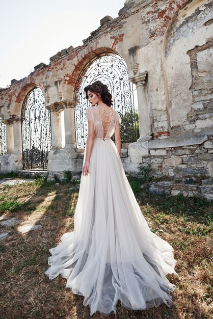 Noiva linda, vestido de noiva, que é fotografado no dia do casamento, perto do castelo velho.