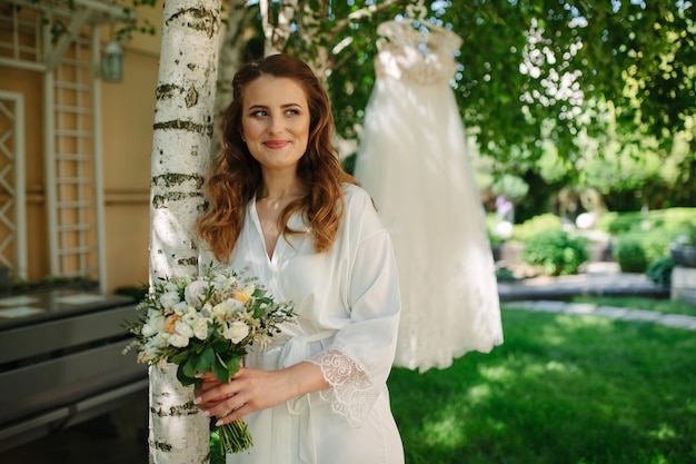 Noiva muito feliz em vestido de luxo com buquê de rosas