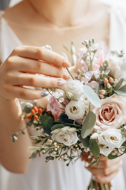 Noiva segurando buquê de casamento com flores brancas e rosa