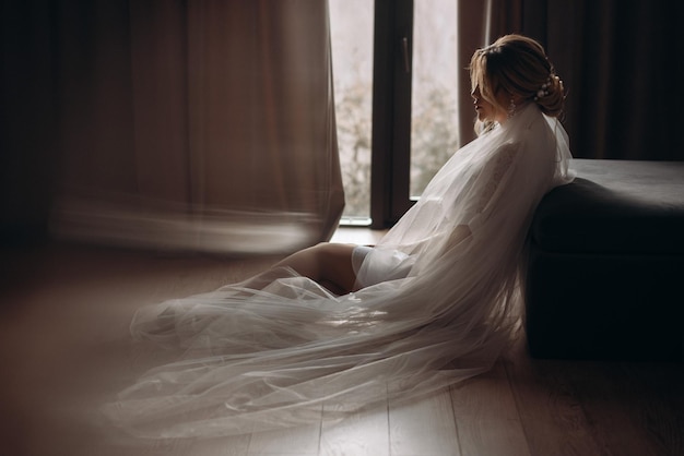 Noiva sentada em uma cadeira olhando pela janela