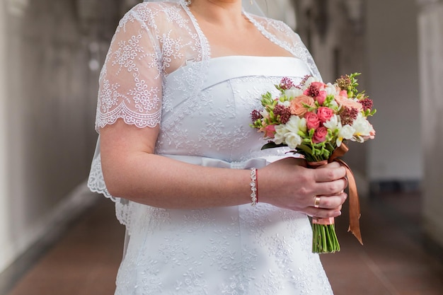 Noiva tem um buquê de casamento em suas mãos