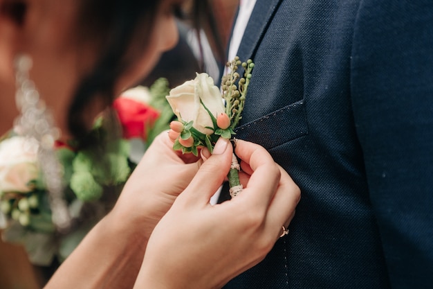 Noiva veste a boutonniere para o noivo