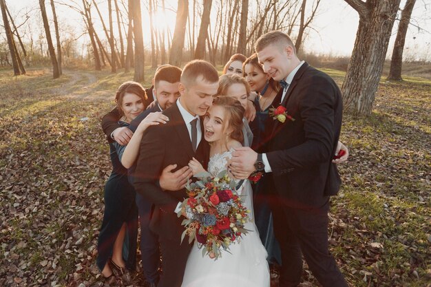 Foto noivas e amigos na natureza amigos no casamento casal recém-casado donas e padrinhos divertindo-se ao ar livre