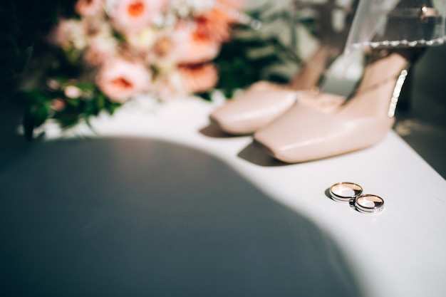 Noivas, sapatos de casamento com um buquê de rosas e outras flores na poltrona tha