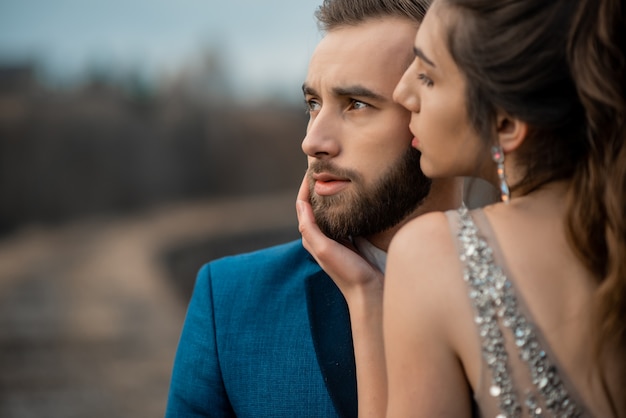 Noivo barbudo e noiva apaixonada com os olhos cheios de felicidade no dia do casamento