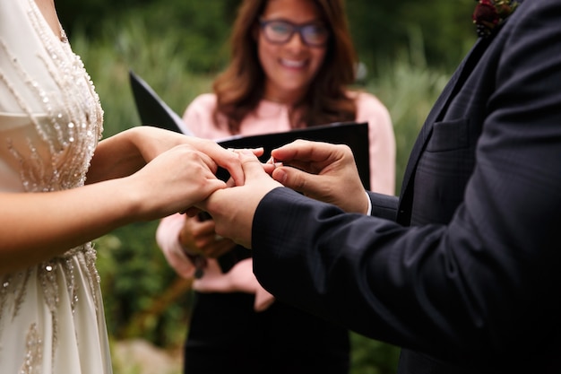 Foto noivo coloca aliança no dedo da noiva