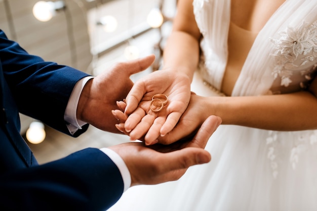 Noivo coloca noiva na aliança de casamento
