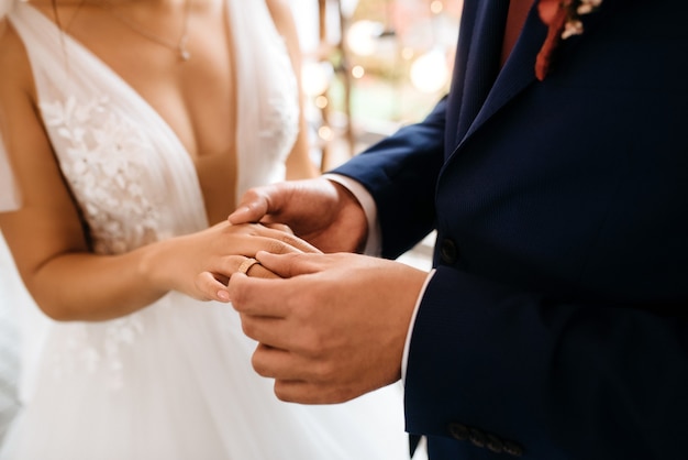 Noivo coloca noiva na aliança de casamento