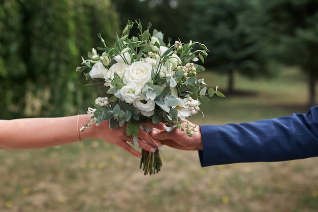 Noivo dá a noiva um lindo bouquet de noiva.