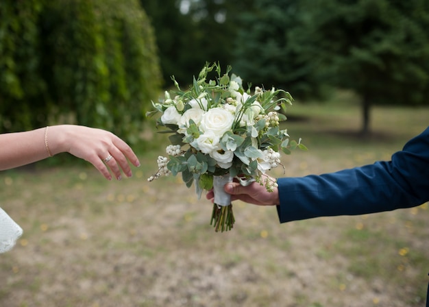 Noivo dá a noiva um lindo buquê de casamento