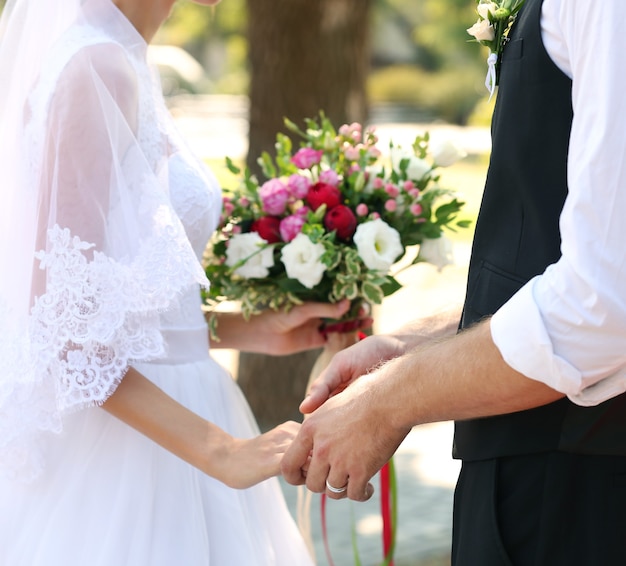 Noivo e noiva com buquê de casamento no parque, closeup