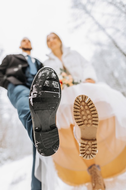 Noivo e noiva em botas de couro em um casamento de inverno Closeup de sapatos de noiva e noivo Casamento no inverno