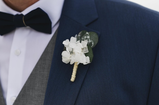 Noivo em um casamento com uma flor na lapela de flores brancas