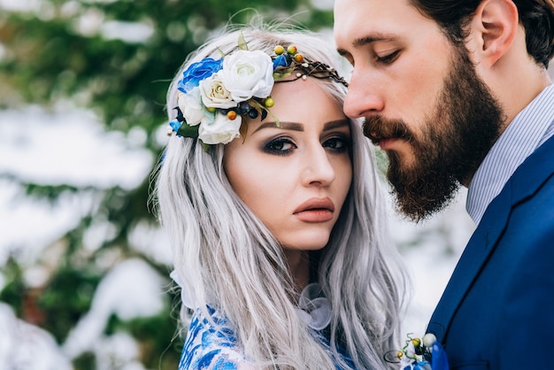 Noivo em um terno azul e noiva em branco, bordado com padrão azul