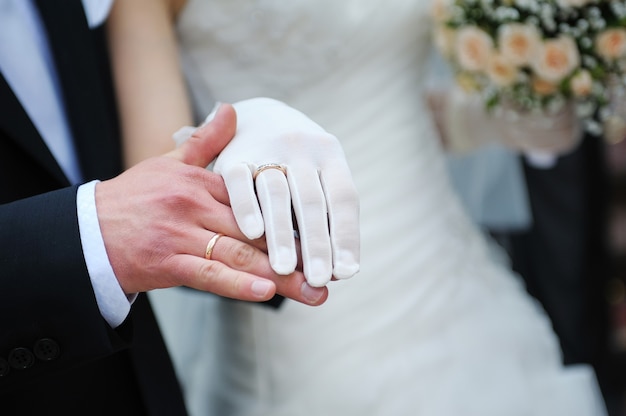 Noivo segura a mão da noiva na cerimônia de casamento