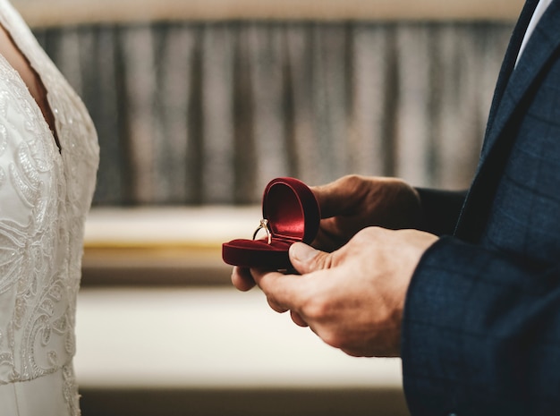 Foto noivo segurando uma caixa com o anel de casamento