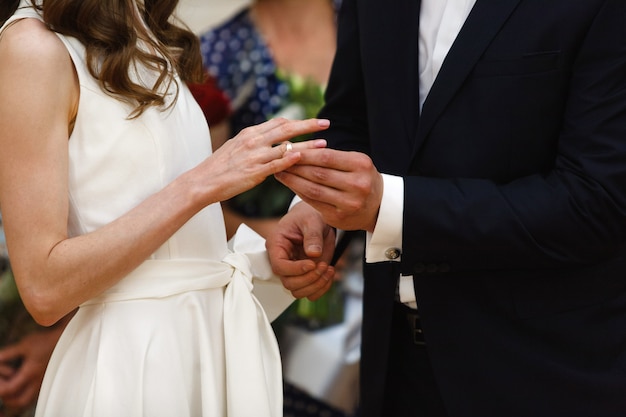 Noivos com anéis nos dedos na cerimônia de casamento day.wedding close-up. o casal troca as alianças de ouro. apenas casal. ele colocou a aliança para ela. noivo colocar anel para noiva