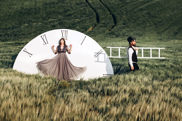 Foto noivos elegantes caminhando e posando em campo verde