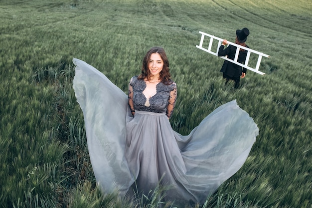 Foto noivos elegantes caminhando e posando em campo verde