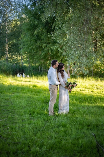 Noivos elegantes que levantam junto ao ar livre em um dia do casamento