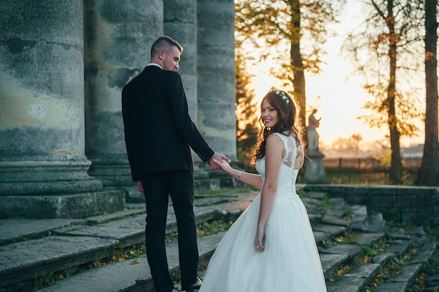 noivos felizes perto do palácio medieval no dia do casamento