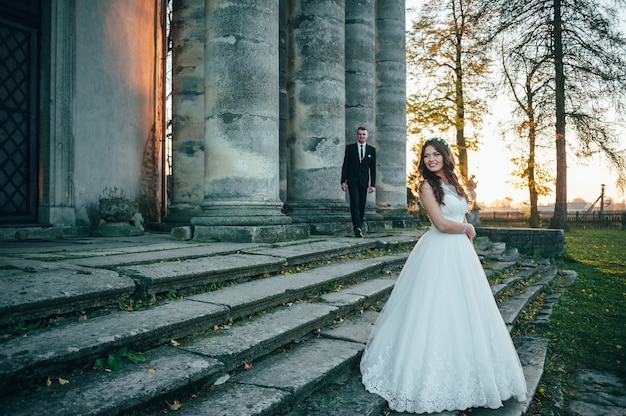 noivos felizes perto do palácio medieval no dia do casamento