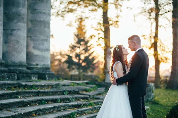 noivos felizes perto do palácio medieval no dia do casamento