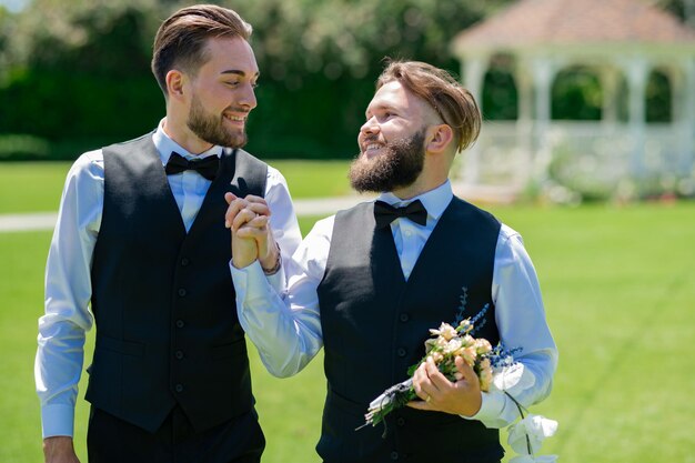 Noivos gays caminhando juntos no dia do casamento casais lgbt celebram uma cerimônia de casamento romântica