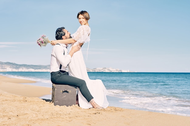 Foto noivos lindos na praia se olhando com muito amor e alegria