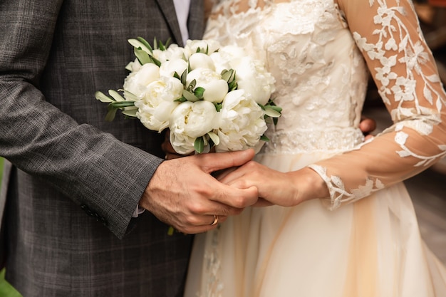 Noivos no dia do casamento, casal de noivos com buquê de flores