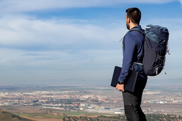 Nômade digital com computador na mão e vista da cidade