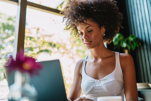 Nômade no trabalho Jovem latina confiante fazendo videochamada no laptop