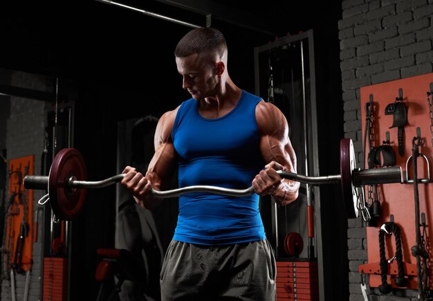 Sin nombre hombre atlético fuerte bombeando músculos entrenamiento culturismo concepto musculoso culturista hombres guapos haciendo ejercicios en el gimnasio desnudo