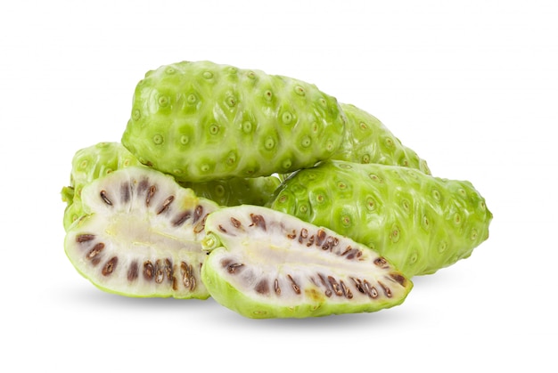 Noni-Frucht mit Blättern auf weißer Wand.