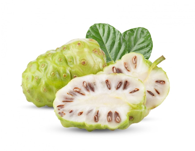 Noni fruta com folhas na mesa branca.