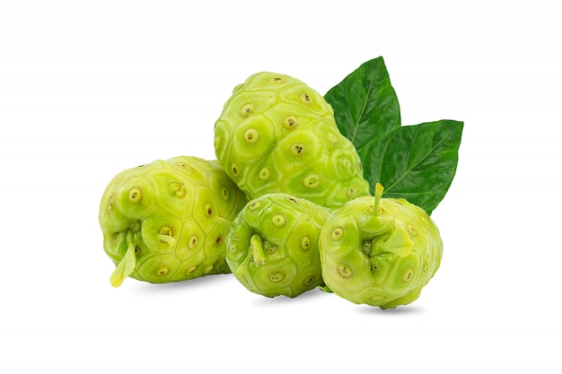 Noni o Morinda Citrifolia y frutas con la mitad en rodajas y hojas verdes aisladas sobre fondo blanco.