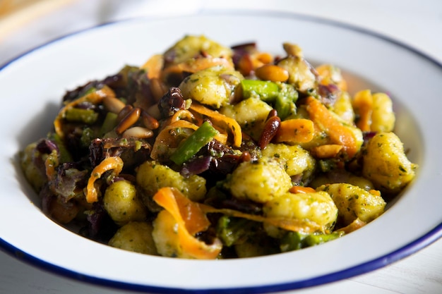 Ñoquis salteados con verduras a la plancha. Receta típica italiana.