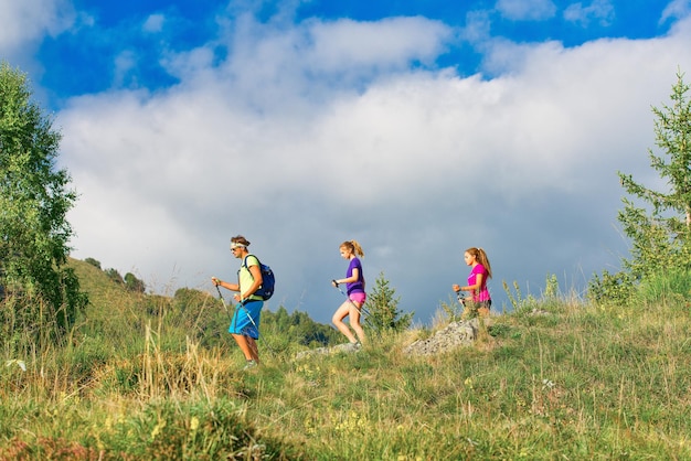 Nordic-Walking-Lehrer mit zwei Mädchen auf Bergpfad