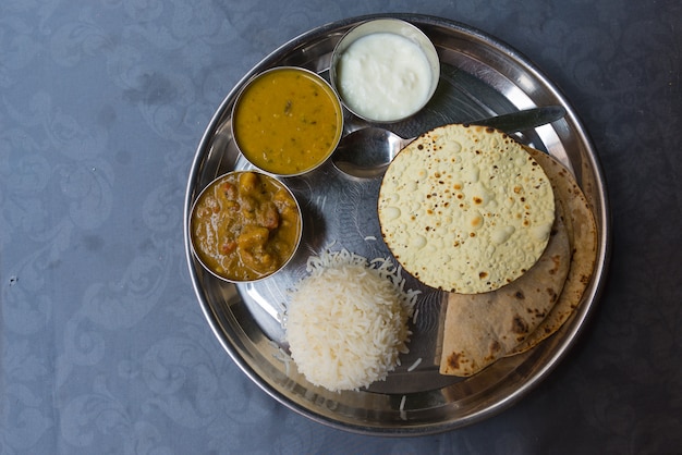 Nordindisches thali, eine tipical Mahlzeit diente auf Edelstahlplatte auf blauer Tabelle