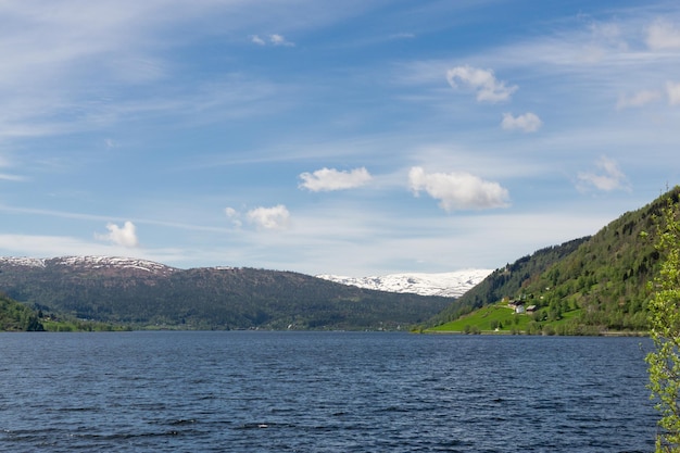 Nordische Landschaft eines Fjords mit schneebedeckten Bergen im Hintergrund