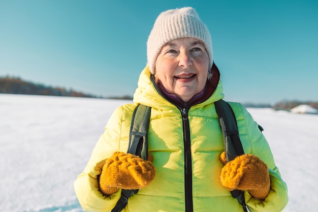 Foto nords ältere frau entspannt sich auf dem hügel, frau trinkt heißen tee aus einer thermo-tasse und genießt