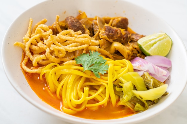 Nordthailändische Nudel-Curry-Suppe mit geschmortem Schweinefleisch - thailändische Küche