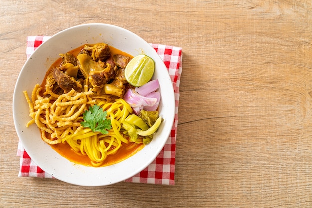 Nordthailändische Nudel-Curry-Suppe mit geschmortem Schweinefleisch