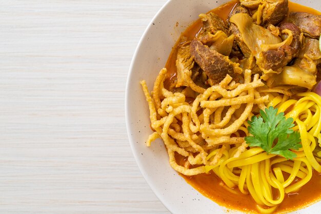 Nordthailändische Nudel-Curry-Suppe mit geschmortem Schweinefleisch