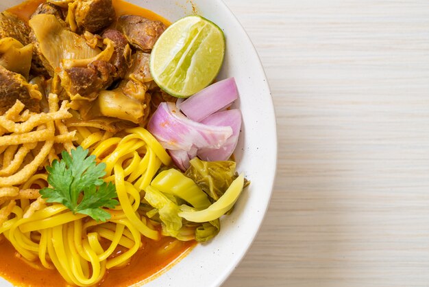 Nordthailändische Nudelcurrysuppe mit geschmortem Schweinefleisch - thailändischer Essensstil