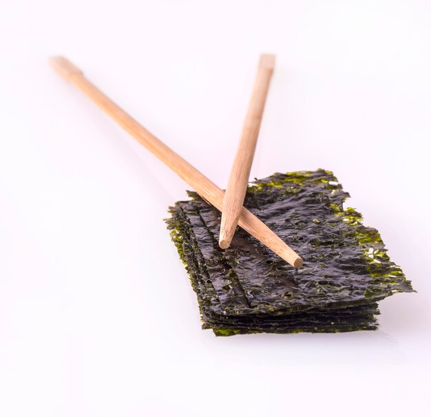 Foto nori-laken mit stöcken auf dem weißen tisch